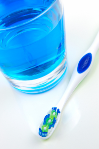 glass with flouride inside, next to toothbrush