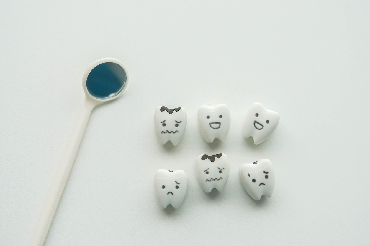 dental mirror, tiny cartoon teeth with various expressions (teeth with cavities look upset)