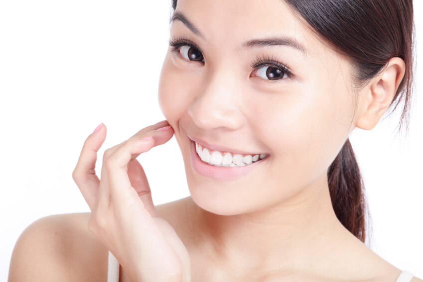 woman smiling and touching cheek