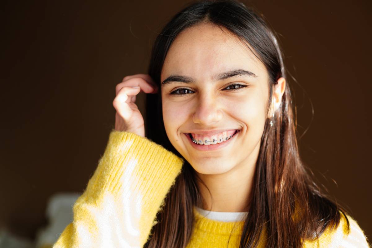 Portrait of a teeth girl with braces smiling at the camera. The serves to represent the relationship between orthodontics and respiratory health.